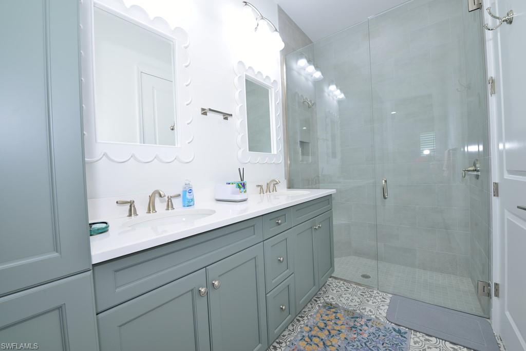 7299 Cayo Coco Lane Naples, FL 34113 - Photo 6 of 18 a bathroom with a shower sink vanity and mirror