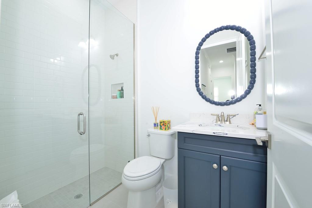 7299 Cayo Coco Lane Naples, FL 34113 - Photo 9 of 18 a bathroom with a toilet a sink and a mirror