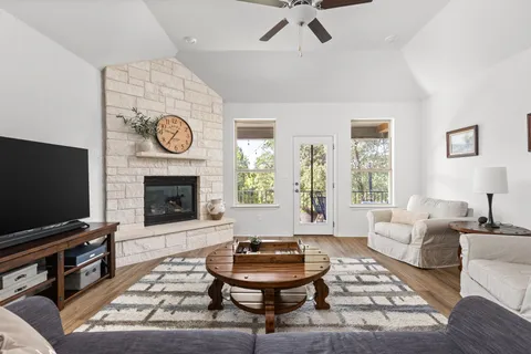 a living room with furniture a flat screen tv and a fireplace