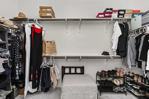 a view of walk in closet with clothes and shoes