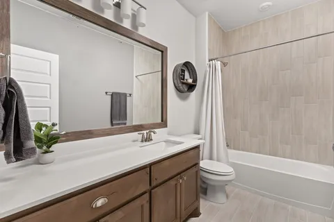 a bathroom with a granite countertop sink a toilet and shower