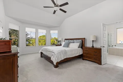 a spacious bedroom with a bed and a dresser