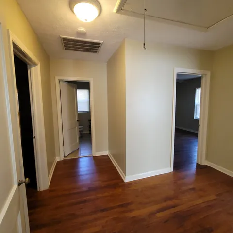 a view of a hallway with wooden floor