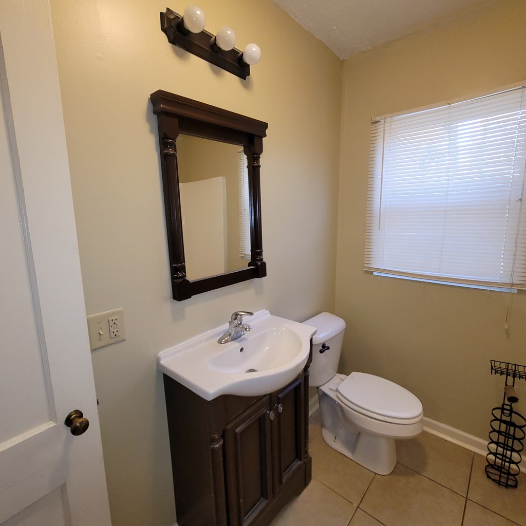 1547 38th Street Columbus, GA 31904 - Photo 24 of 24 a bathroom with a toilet sink and mirror