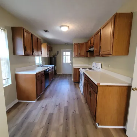 a kitchen with a sink a counter top space stainless steel appliances and cabinets