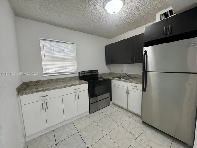 a kitchen with granite countertop white cabinets and white appliances