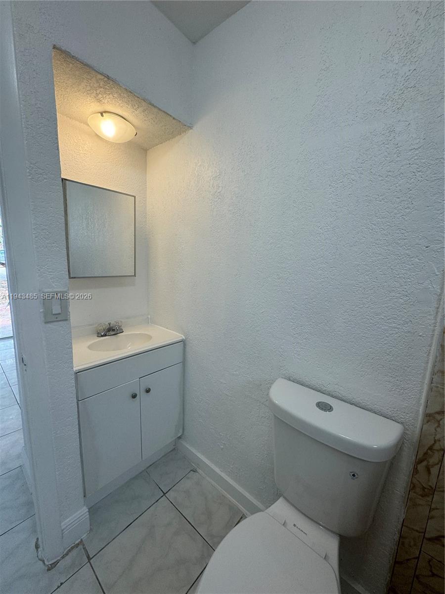 5819 Moseley Street Hollywood, FL 33021 - Photo 8 of 15 a bathroom with a sink a toilet and mirror