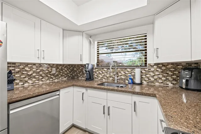 a kitchen with granite countertop white cabinets and white appliances