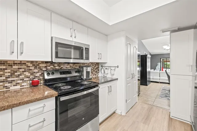 a kitchen with stainless steel appliances granite countertop a stove a sink and a refrigerator