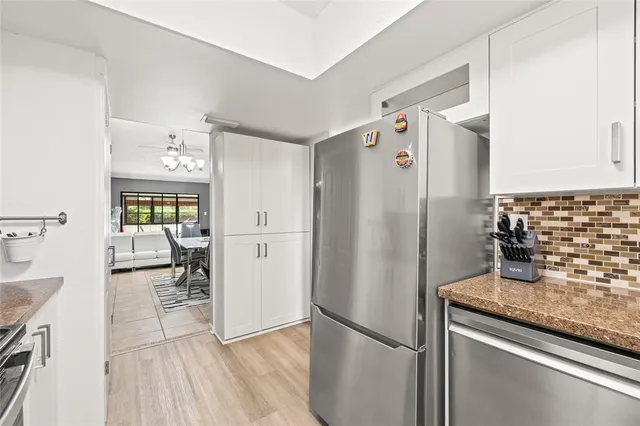 a kitchen with granite countertop a refrigerator and a sink