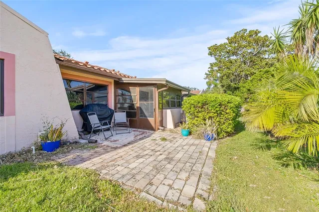 a view of patio with table and chairs and potted plants