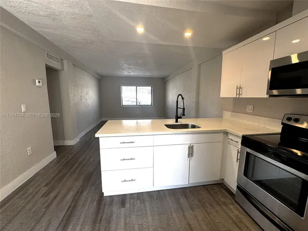 a kitchen with kitchen island a refrigerator sink and stove