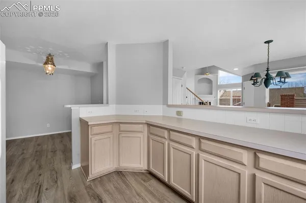 a kitchen with white cabinets and sink