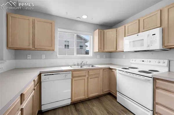 a kitchen with stainless steel appliances granite countertop a sink and cabinets with wooden floors