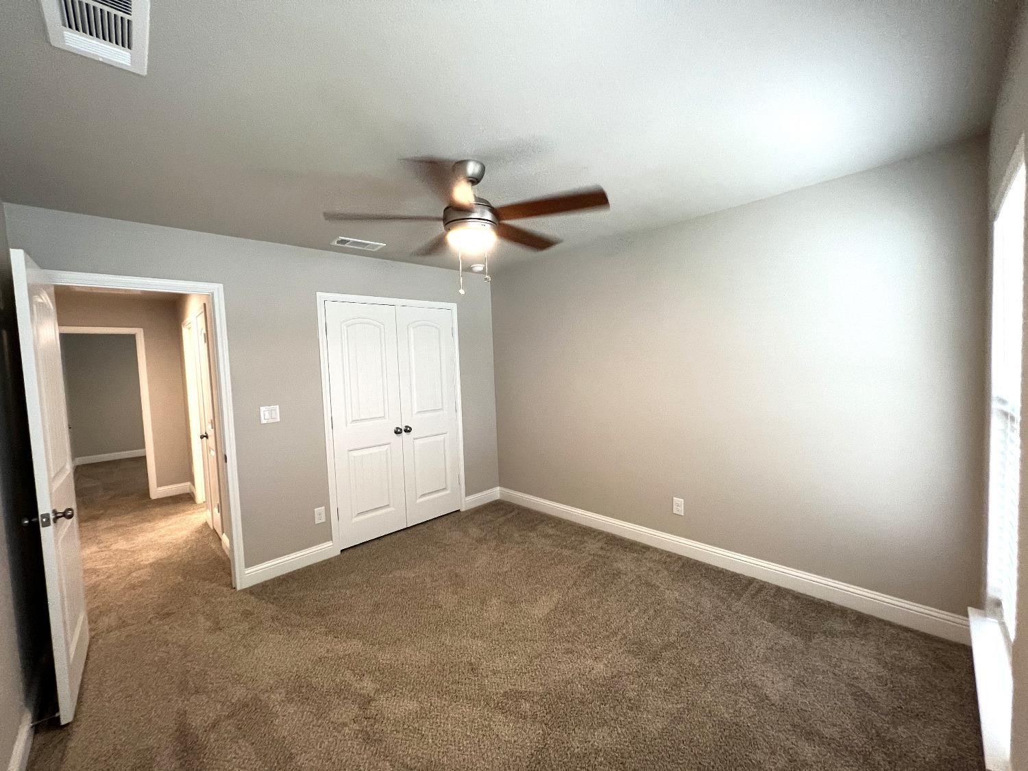 7506 100th Street Lubbock, TX 79424 - Photo 5 of 23 an empty room with a ceiling fan and a window