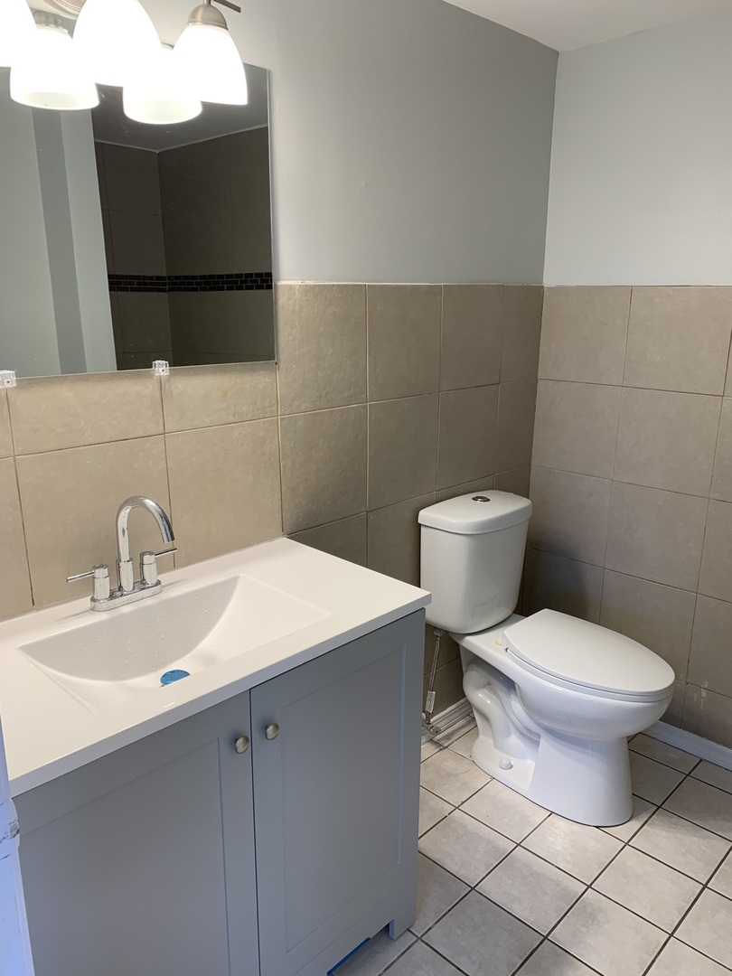 15339 9th Avenue Phoenix, IL 60426 - Photo 8 of 13 a bathroom with a sink toilet and mirror