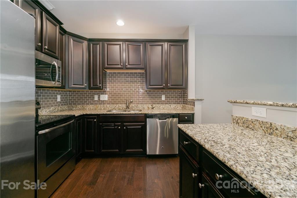 7304 Copper Beech Trace, Unit 13 Charlotte, NC 28273 - Photo 2 of 25 a kitchen with stainless steel appliances granite countertop a sink stove and cabinets
