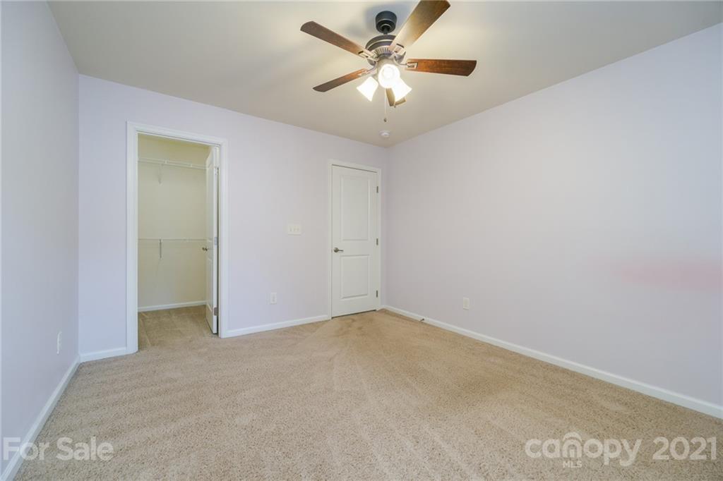 7304 Copper Beech Trace, Unit 13 Charlotte, NC 28273 - Photo 14 of 25 an empty room with a chandelier fan and a ceiling fan