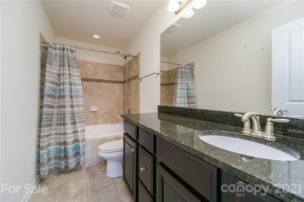 7304 Copper Beech Trace, Unit 13 Charlotte, NC 28273 - Photo 19 of 25 a bathroom with a granite countertop sink toilet and shower