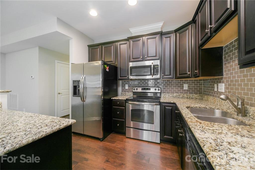 7304 Copper Beech Trace, Unit 13 Charlotte, NC 28273 - Photo 3 of 25 a kitchen with stainless steel appliances granite countertop a sink stove and refrigerator
