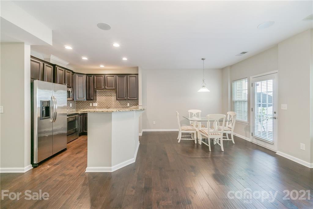 7304 Copper Beech Trace, Unit 13 Charlotte, NC 28273 - Photo 21 of 25 a kitchen with stainless steel appliances granite countertop a stove top oven a sink a dining table and chairs