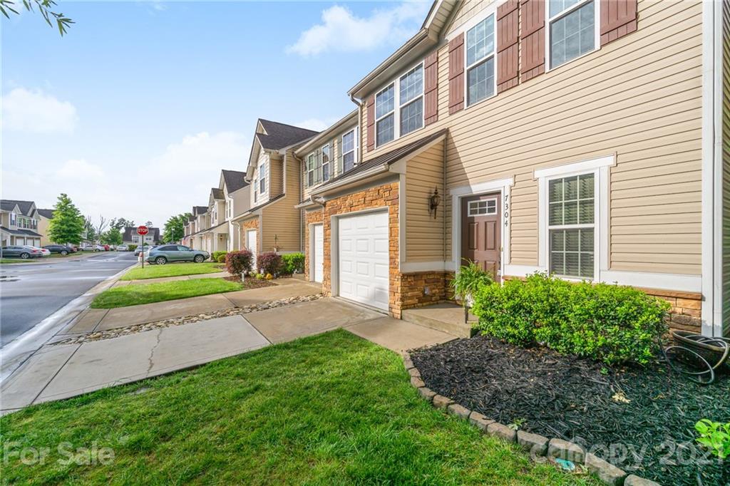 7304 Copper Beech Trace, Unit 13 Charlotte, NC 28273 - Photo 24 of 25 a view of a house with a yard and sitting area