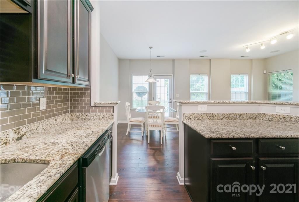 7304 Copper Beech Trace, Unit 13 Charlotte, NC 28273 - Photo 4 of 25 a kitchen with center island table and chairs