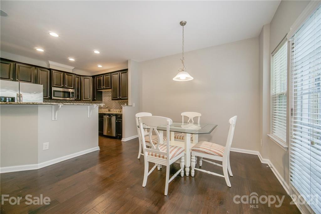 7304 Copper Beech Trace, Unit 13 Charlotte, NC 28273 - Photo 8 of 25 a view of a dining room that has a table chairs and wooden floor