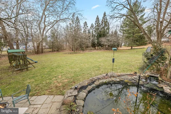 a view of a lake with a bench and trees around