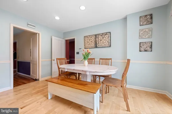 a living room with dining table and paintings on the wall