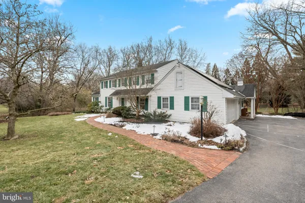 a front view of house with yard and trees in the background