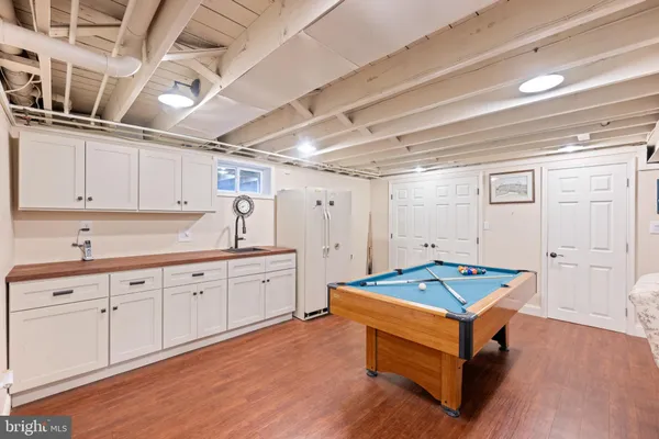 a room with pool table and wooden cabinets
