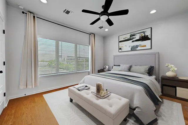 a bedroom with a bed and a large window