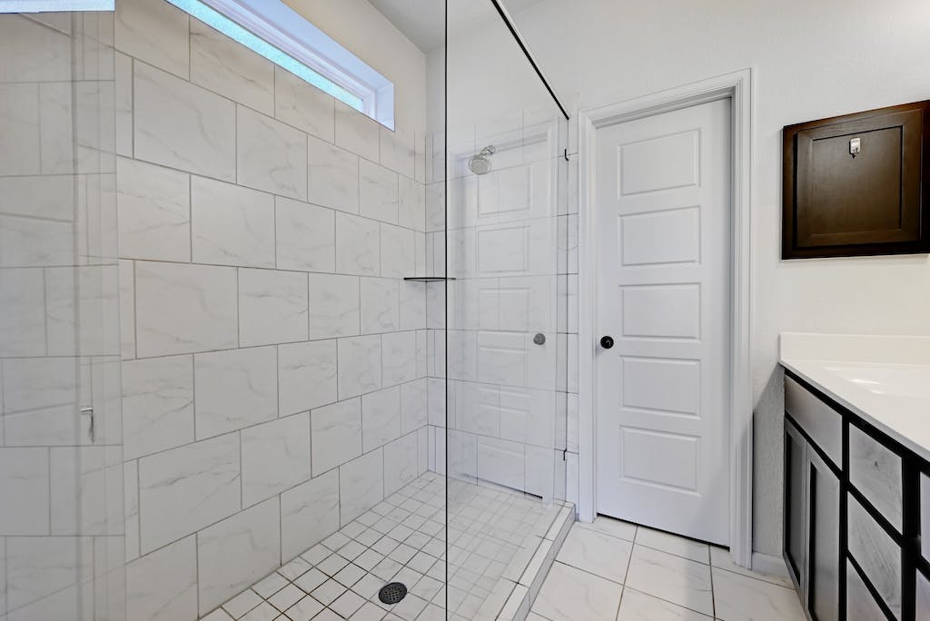 1412 Waterloo Shore Lane Austin, TX 78741 - Photo 15 of 30 a bathroom with a shower and a mirror