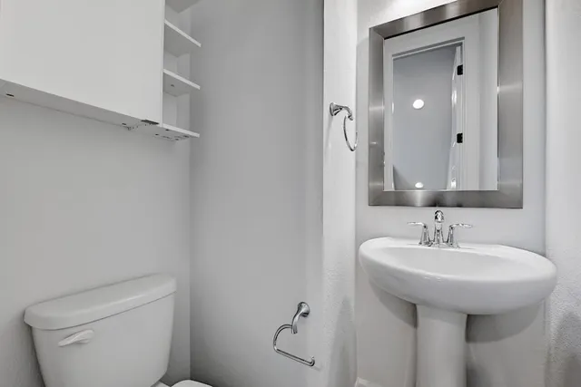 a bathroom with a sink toilet and mirror