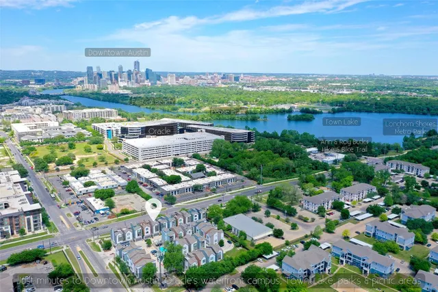 an aerial view of a city with lots of residential buildings ocean and mountain view in back