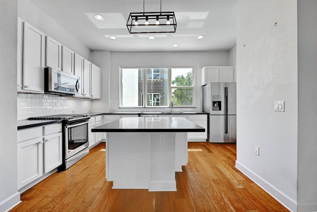 1412 Waterloo Shore Lane Austin, TX 78741 - Photo 6 of 30 a kitchen with stainless steel appliances granite countertop a stove a sink and a refrigerator