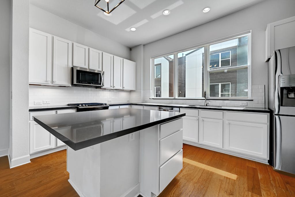 1412 Waterloo Shore Lane Austin, TX 78741 - Photo 9 of 30 a kitchen with stainless steel appliances granite countertop a sink a stove and a refrigerator