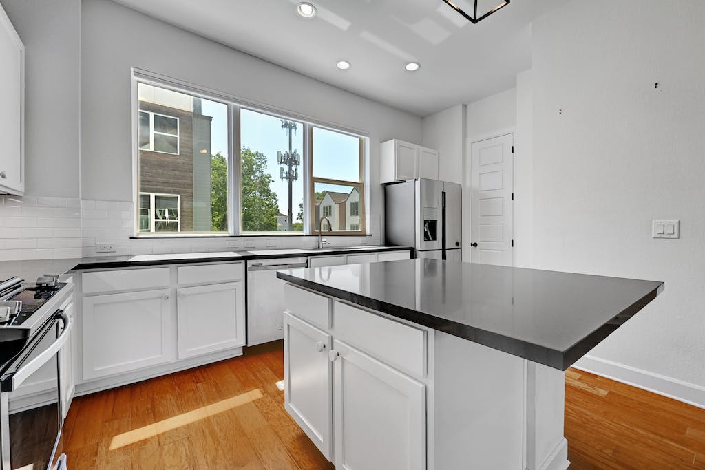 1412 Waterloo Shore Lane Austin, TX 78741 - Photo 10 of 30 a kitchen with stainless steel appliances granite countertop a sink a stove and a refrigerator