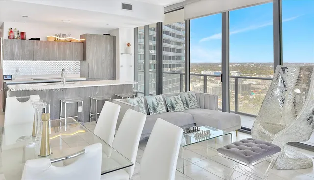 a living room with furniture and a floor to ceiling window