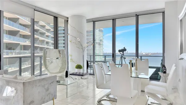 a living room with furniture and floor to ceiling windows