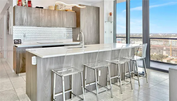 a kitchen with a sink and chairs