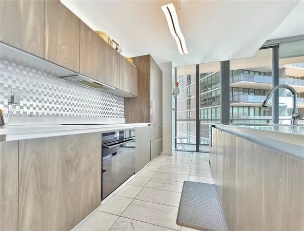 a kitchen with granite countertop a refrigerator a sink and dishwasher with a large window