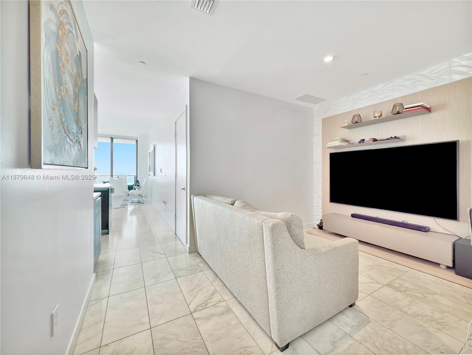 480 Northeast 31st Street, Unit 2407 Miami, FL 33137 - Photo 19 of 35 a living room with furniture and a flat screen tv