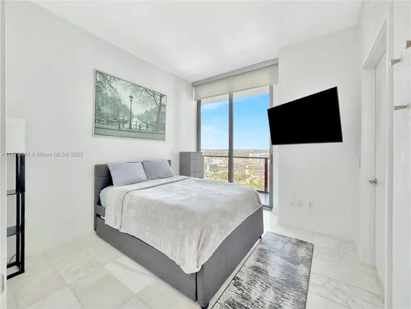 a bedroom with a bed and a flat screen tv