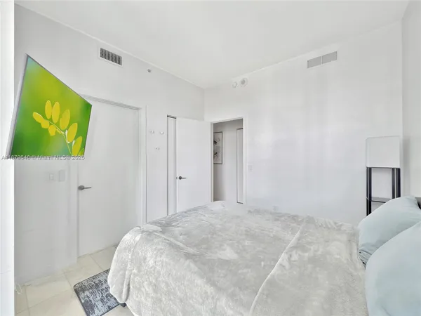 a bedroom with a bed and a painting on the wall
