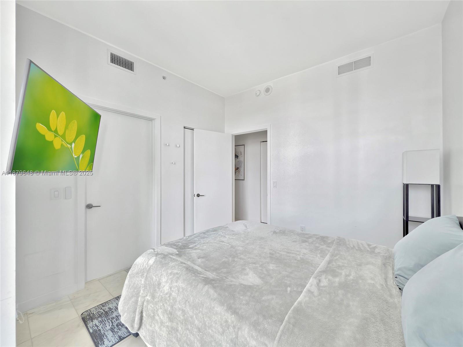 480 Northeast 31st Street, Unit 2407 Miami, FL 33137 - Photo 24 of 35 a bedroom with a bed and a painting on the wall