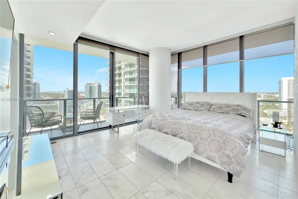 a spacious bedroom with a large window and a bed