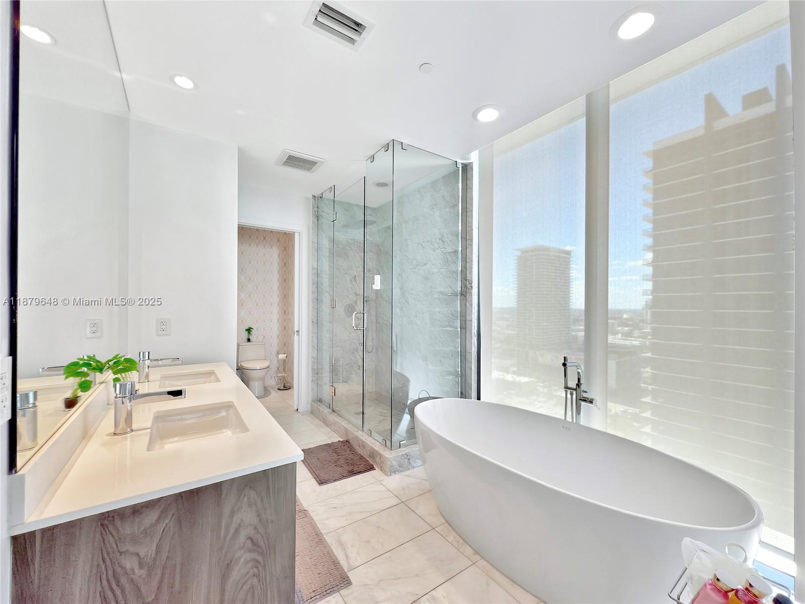 480 Northeast 31st Street, Unit 2407 Miami, FL 33137 - Photo 29 of 35 a bathroom with a tub sink and mirror