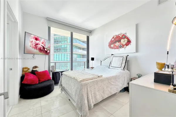 a bedroom with a bed and a large window